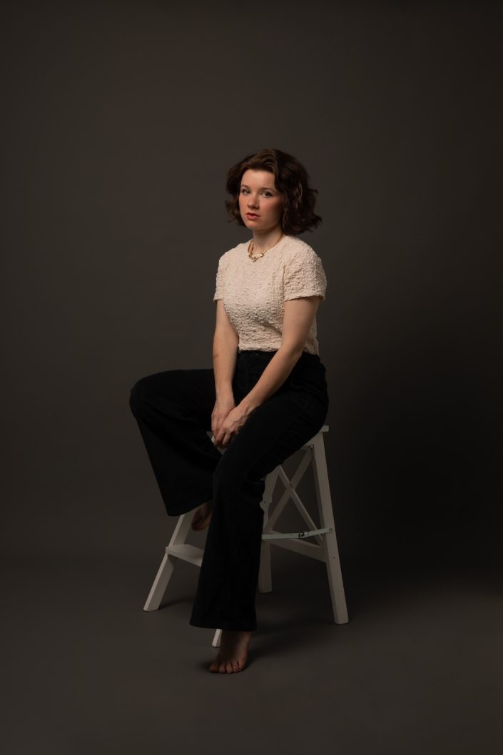 Photographe-portrait-studio-Paris-shooting-séance-photo-corporate-linkedin-professionnel-femme-assise-tabouret-FQ3A5078 copie
